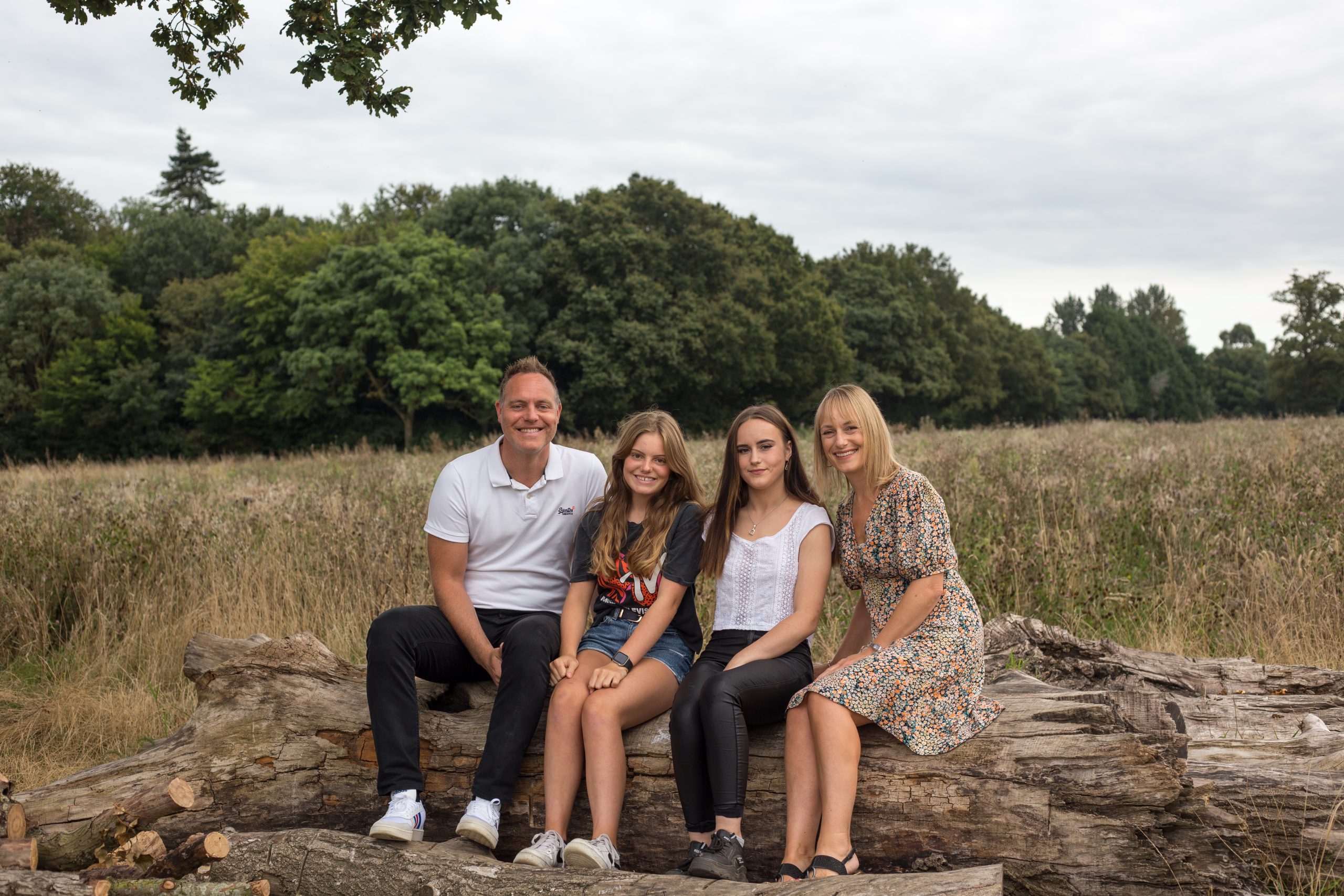 Photographer in Colchester - family in a field sitting on a big tree trunk